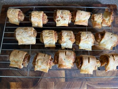 Veggie sausage rolls cooling on the wire rack on the chopping board