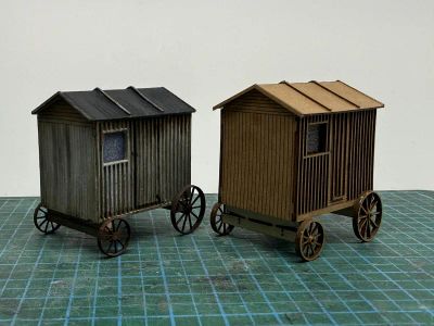 Original shepherds hut model on left painted weathered grey and on the right is the new version unpainted.