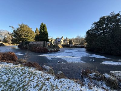 Wide shot of Old Scotney Castle from the North West side with frozen lake.